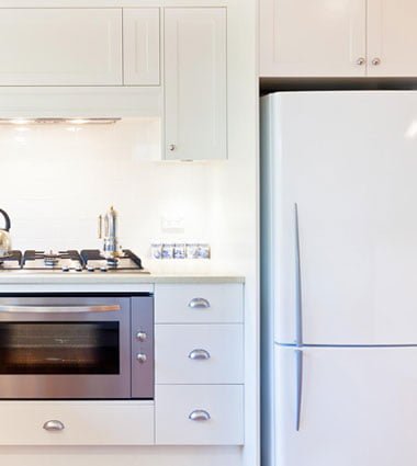 white fridge and chromium oven in a white domestic kitchen